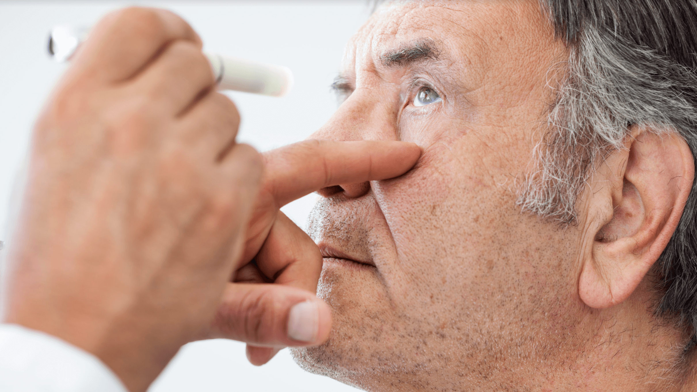 doctor looking in man's eye